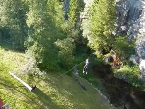 Frau am Schwebeseil über einem Teich. Acrosphere Gerardmer.