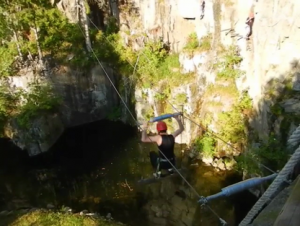 Homme sur une tyrolienne avec deux filins porteurs.