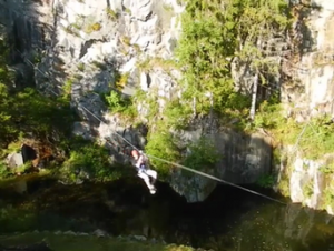 Man on a zip-line above a lake. Acrosphere. Man on a zip-line above a lake. Acrosphere.
